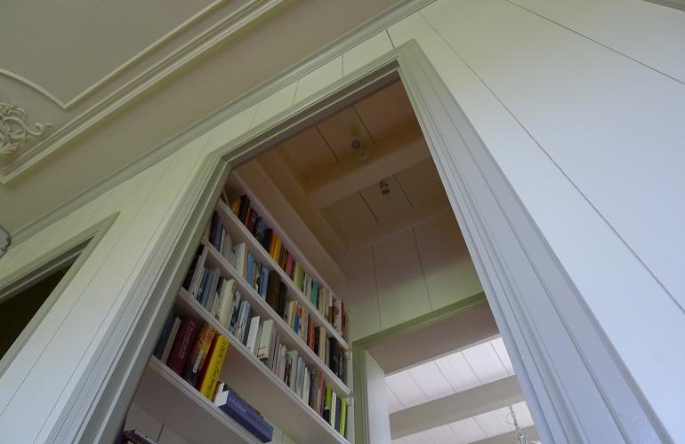 Een kleine bibliotheekkamer in bedstee en de teruggebrachte balken aan het plafond en in het bibliotheekkamertje.